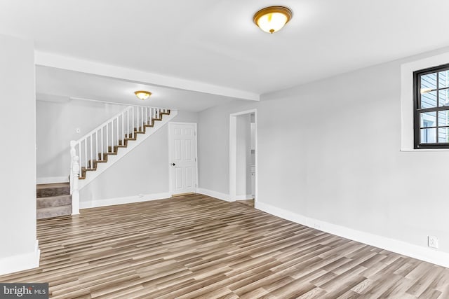 interior space with baseboards, stairway, and wood finished floors