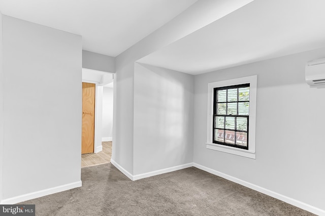 carpeted spare room featuring a wall mounted AC