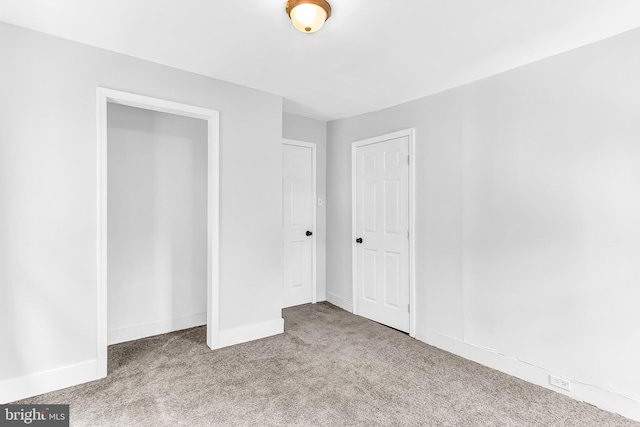 unfurnished bedroom with baseboards and light colored carpet