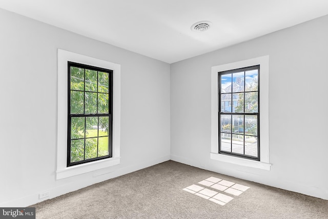 empty room featuring carpet and visible vents