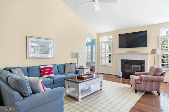 living room featuring hardwood / wood-style flooring, high vaulted ceiling, and ceiling fan