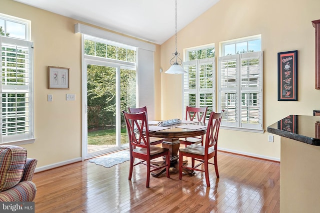 dining area with hardwood / wood-style flooring and vaulted ceiling