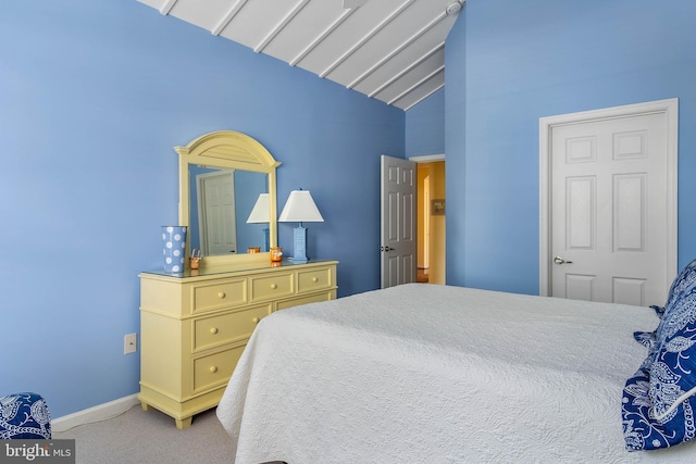 bedroom with light colored carpet and vaulted ceiling