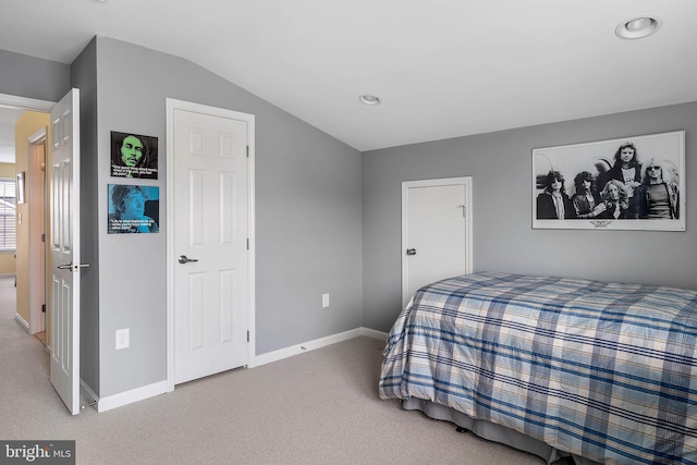 carpeted bedroom with lofted ceiling