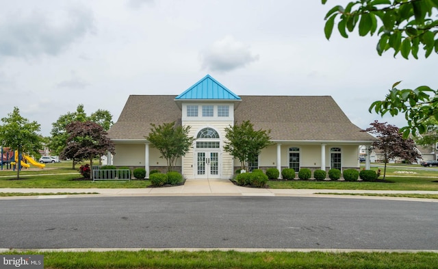 view of front of home with a playground and a front lawn