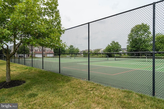 view of tennis court featuring a yard