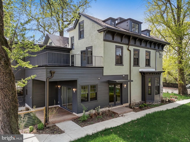 view of front of home featuring a balcony and a front lawn