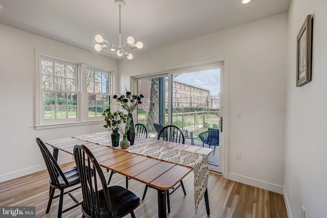 dining space with light hardwood / wood-style flooring and a chandelier