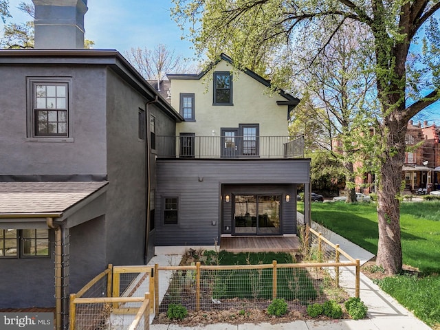 back of house featuring a yard and a balcony