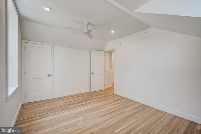 unfurnished bedroom with lofted ceiling, ceiling fan, and light wood-type flooring