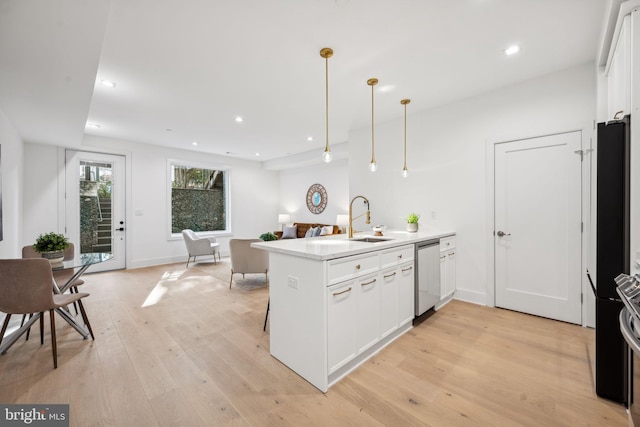 kitchen featuring light wood-type flooring, kitchen peninsula, dishwasher, pendant lighting, and white cabinets