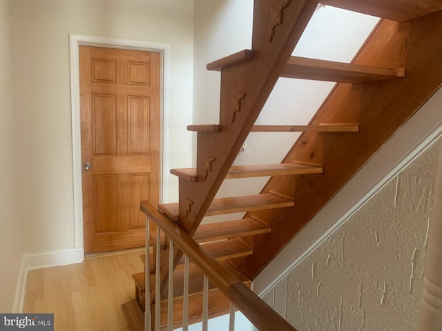 stairway with light hardwood / wood-style flooring