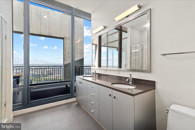 bathroom with toilet, tile flooring, and dual vanity