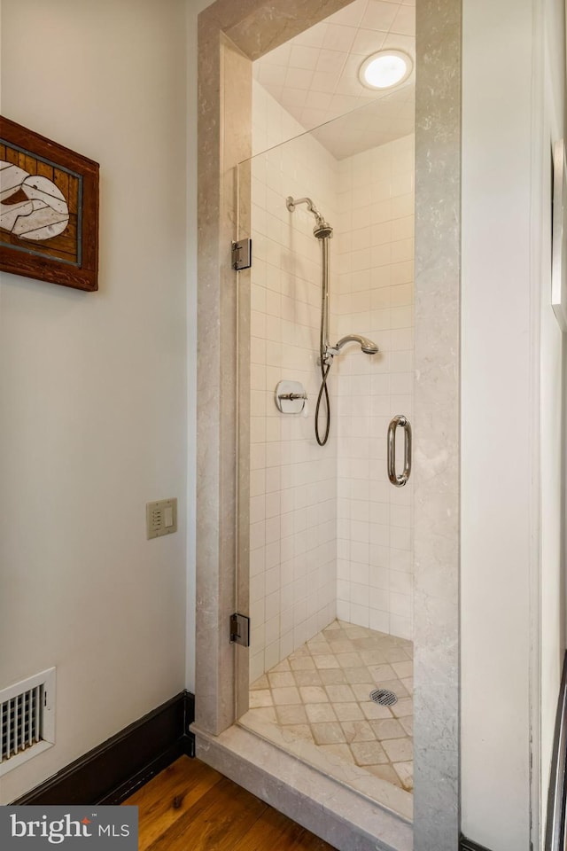 bathroom with an enclosed shower and hardwood / wood-style flooring