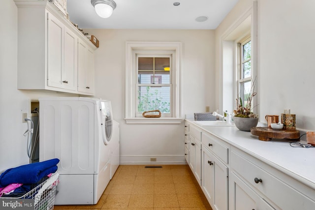 laundry area with washer and dryer, sink, and cabinets