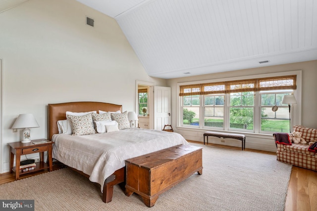 bedroom with light hardwood / wood-style flooring and lofted ceiling