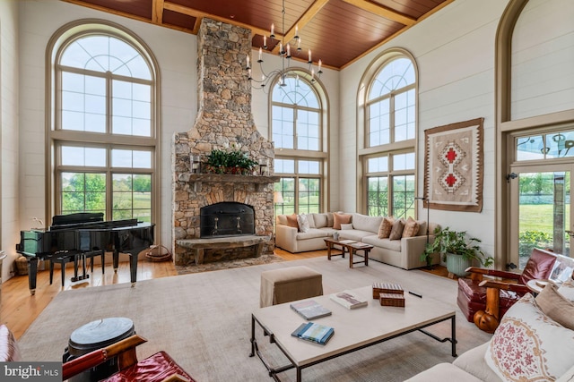 living room featuring light hardwood / wood-style flooring, wood ceiling, and a high ceiling