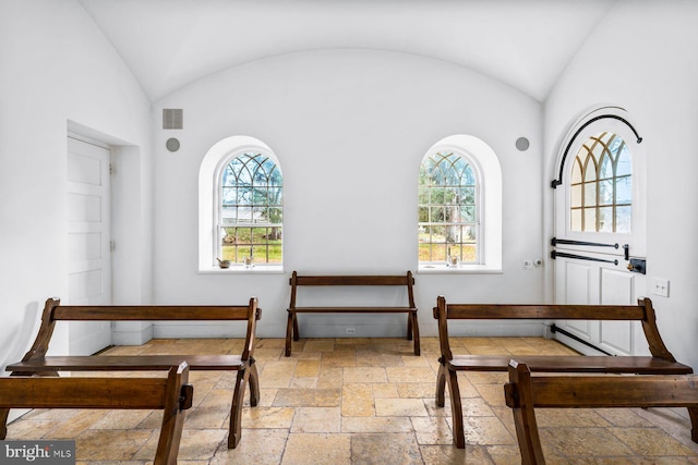 sitting room with vaulted ceiling, a healthy amount of sunlight, and tile floors