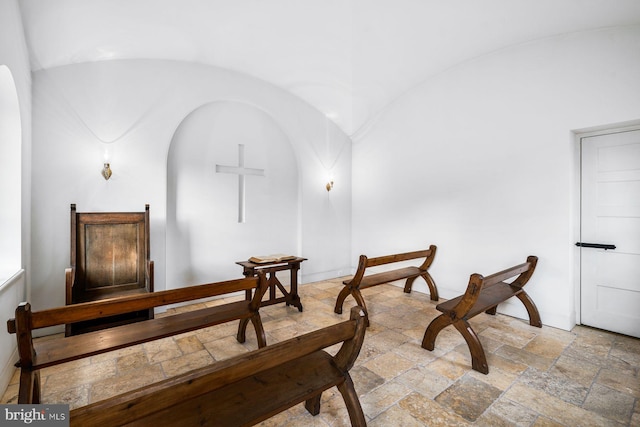 sitting room with tile flooring and vaulted ceiling