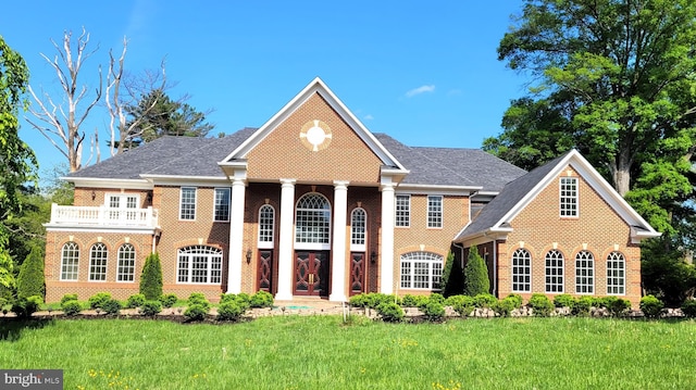 view of front facade with a balcony and a front lawn