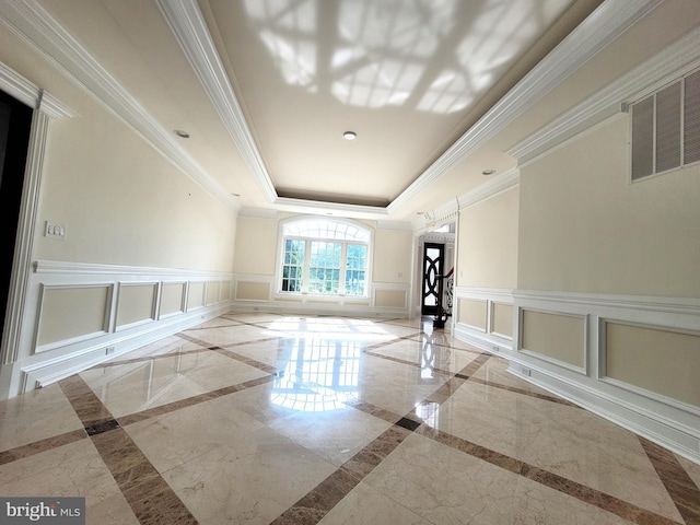 interior space with a raised ceiling and crown molding