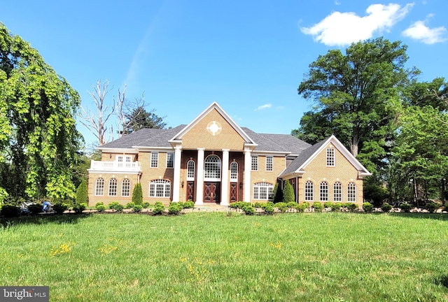 neoclassical home featuring a front yard