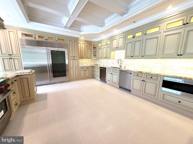 kitchen featuring green cabinetry, tasteful backsplash, beamed ceiling, light stone counters, and stainless steel appliances