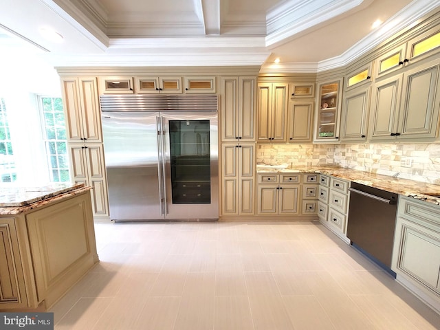 kitchen with decorative backsplash, stainless steel appliances, light stone counters, and crown molding