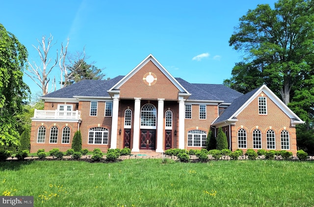 view of front facade featuring a balcony and a front yard