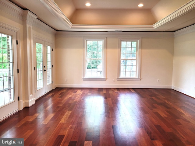 empty room with plenty of natural light, dark hardwood / wood-style flooring, crown molding, and french doors