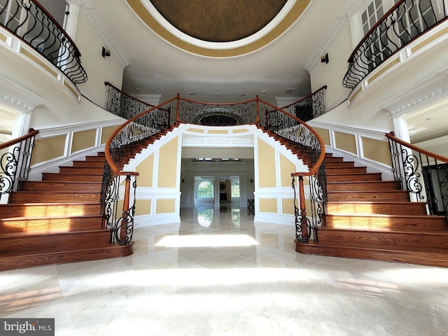 stairway featuring french doors and a towering ceiling