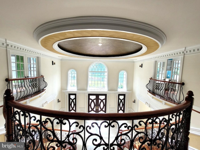 interior details featuring french doors, a tray ceiling, and ornamental molding