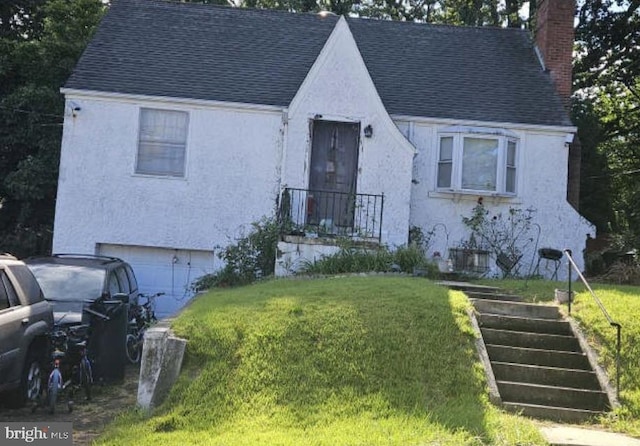 view of front of house with a garage and a front lawn