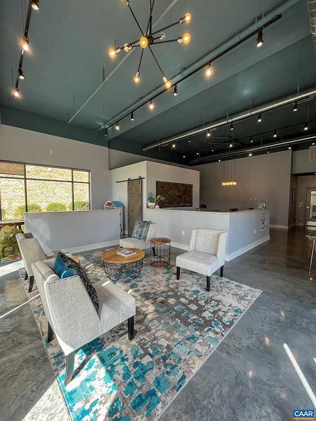 interior space with concrete flooring, track lighting, and a barn door