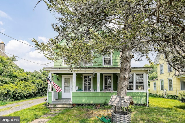 bungalow-style home with covered porch and a front yard