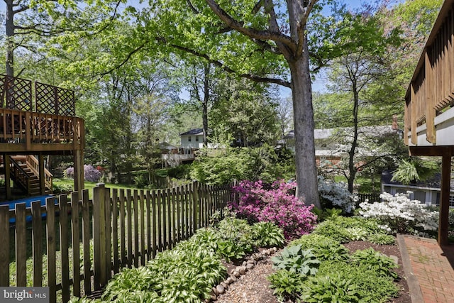 view of yard featuring fence, a deck, and stairs