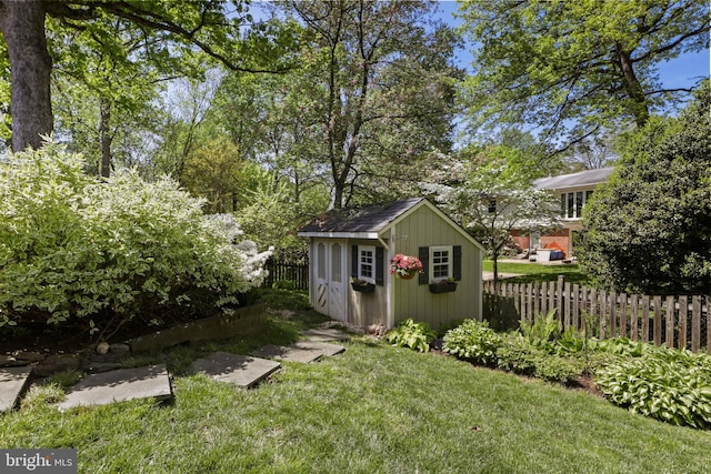 exterior space with an outbuilding, a storage unit, and a fenced backyard