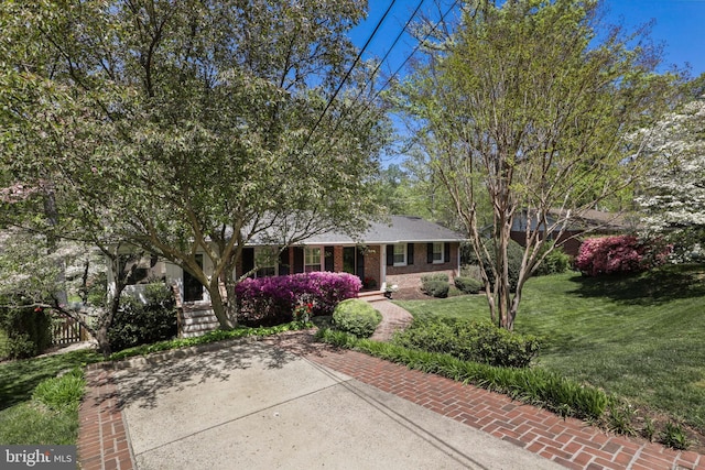 ranch-style house featuring a front yard, brick siding, and fence