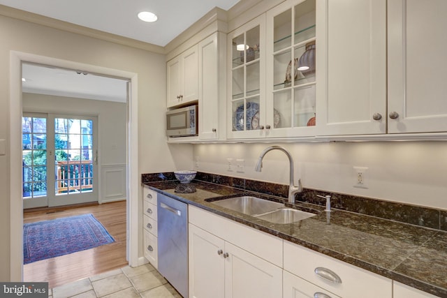 kitchen with appliances with stainless steel finishes, white cabinets, and a sink