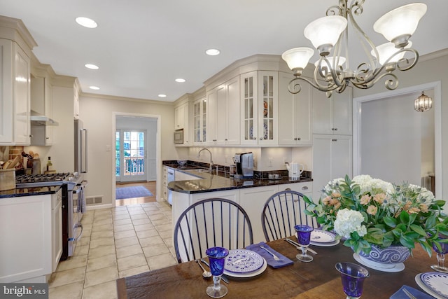 kitchen with light tile patterned flooring, a sink, white cabinets, appliances with stainless steel finishes, and glass insert cabinets