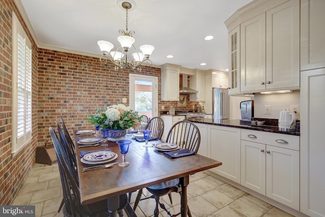 dining room featuring brick wall, recessed lighting, and an inviting chandelier