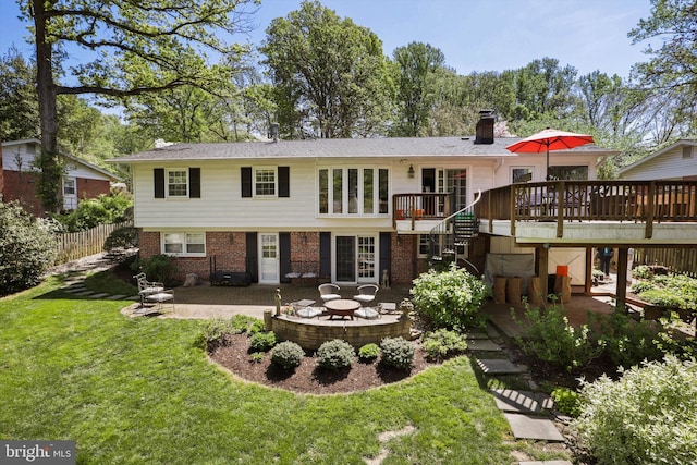 view of front of home featuring brick siding, a chimney, stairway, a front yard, and a patio area