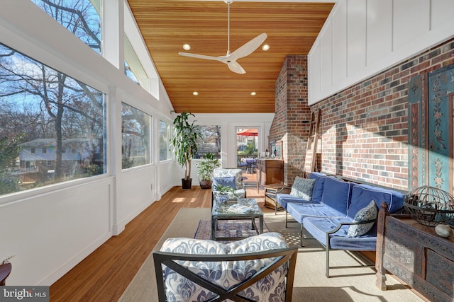 sunroom featuring wooden ceiling and a ceiling fan