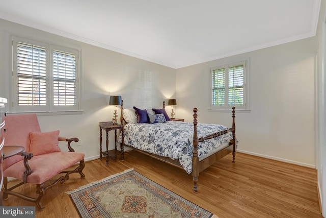 bedroom with baseboards, ornamental molding, and wood finished floors