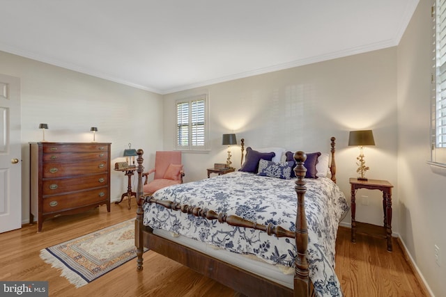 bedroom featuring crown molding, baseboards, and wood finished floors