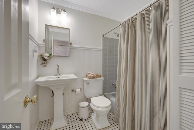 bathroom with toilet, tile patterned floors, shower / bath combo, and wainscoting