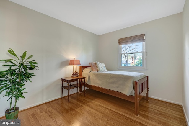 bedroom with light wood finished floors and baseboards