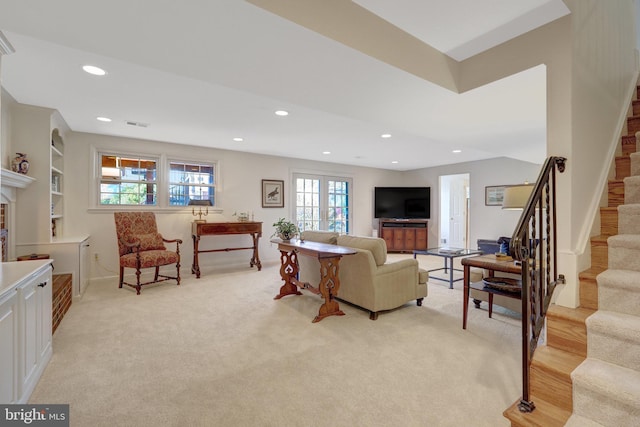 living area featuring recessed lighting, light colored carpet, and stairway