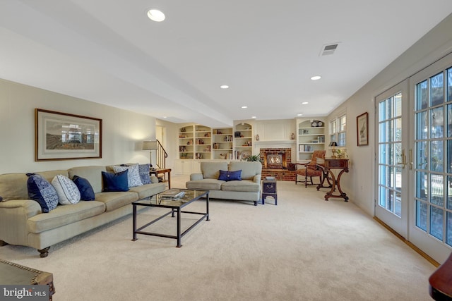 living area with recessed lighting, light colored carpet, visible vents, french doors, and a brick fireplace