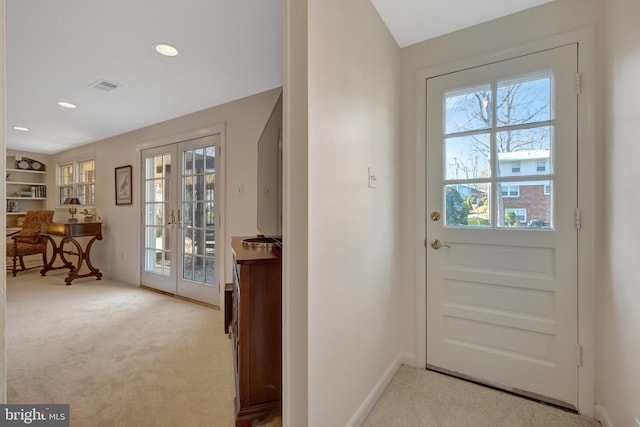 entryway with carpet floors, french doors, visible vents, and plenty of natural light